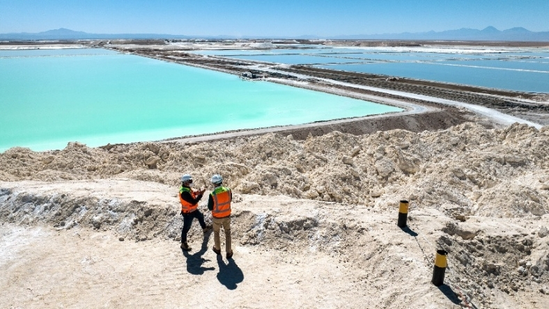 Engineers overlooking lithium brine ponds at industrial extraction site