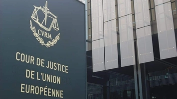 Dark exterior panel sign reading Cour de Justice de l'Union Européenne with the gold CURIA emblem above